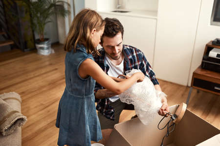 Unpacking together. a young father and his adorable little daughter on their moving day.の写真素材