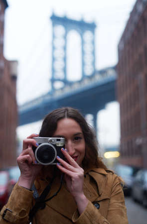 Making big memories in the big city. Portrait of an attractive young woman taking pictures with a...
