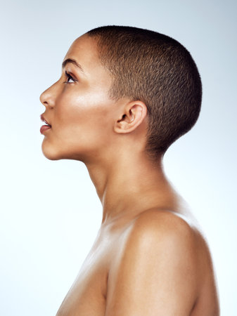 Be the kind of person who empowers. Profile shot of a beautiful young woman posing against a grey background.の写真素材