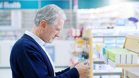 Its never too late to choose living a healthier life. Close up shot of a senior citizen deciding on which medicine to purchase at a pharmacy.の写真素材