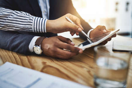 It pays to work smarter. Closeup shot of two businesspeople working together on a digital tablet in...