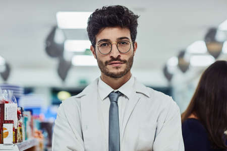 Hes always courteous and professional. Cropped portrait of a handsome young male pharmacist working in a pharmacy.の写真素材