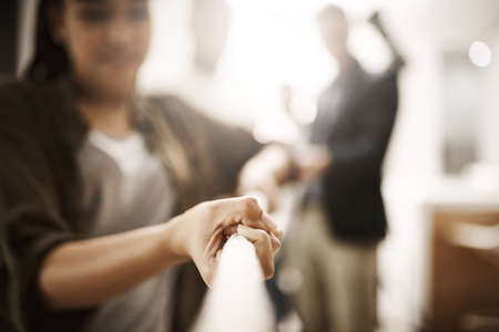 Business competition, rivalry or challenge of a woman pulling a rope in the office. Corporate professional having a dispute at a company or workplace. Employees playing tug of war for team buildingの写真素材