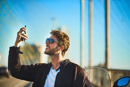 Theres nothing wrong with being confident. a young man riding a motorbike through the city.の写真素材