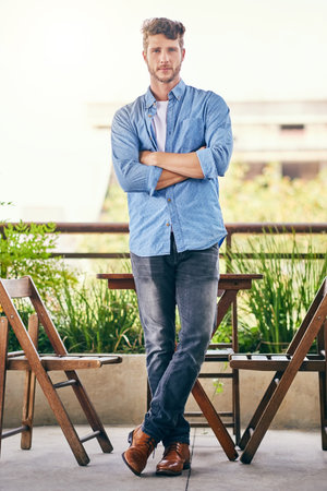 Confidence is his charm. Portrait of a handsome young businessman standing outdoors.の写真素材