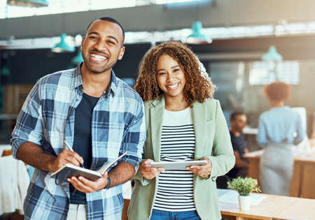 Success has us smiling broadly. Portrait of two young designers working in an office.の写真素材