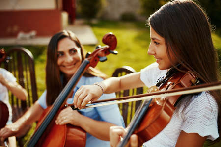 Ive learnt my love for music from my mother. a beautiful mother playing instruments with her adorable daughter outdoors.の写真素材