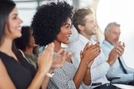 Credit where credit is due. an attractive young businesswoman applauding during a seminar.の写真素材