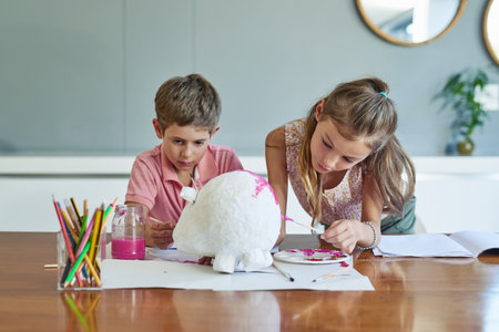 Getting creative with paint. two adorable little siblings painting together at home.の写真素材