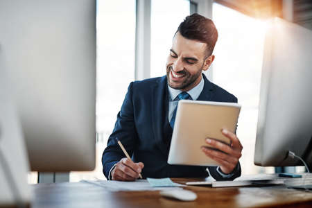 He worked hard for his business dreams. a handsome male executive working in a modern office.の写真素材