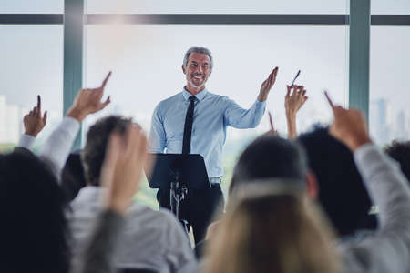 I will answer as many of you as possible. a handsome mature male speaker fielding questions during a...