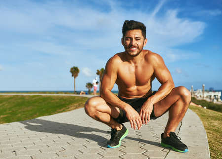 Fitness definitely pays off. Portrait of a handsome young man exercising outdoors.の写真素材