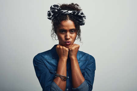 She may be cute until you mess with her. Studio shot of an attractive young woman posing against a...