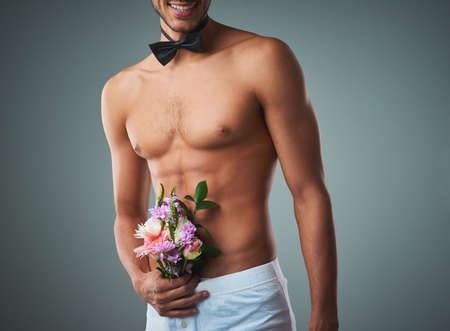 That was one crazy bachelor party. Studio shot of a handsome young shirtless man posing against a grey background.の写真素材