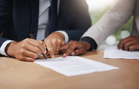 Please sign here if you agree with the terms. Closeup shot of two unrecognizable businesspeople...