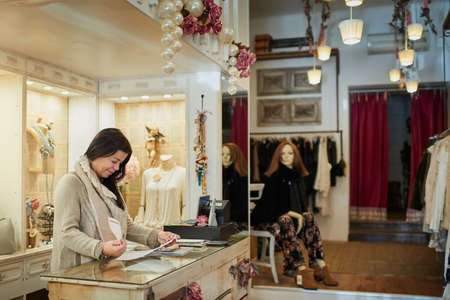 Checking over some paperwork. an attractive mature female entrepreneur reading a document while...