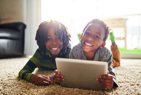 Learning is much more fun when we do it online. two little boys using a digital tablet together.
