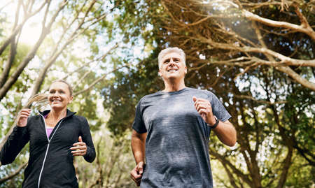 Fit, active and healthy mature couple jogging, running and enjoying their fitness lifestyle outside...