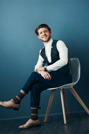 Looking dapper in his business attire. Studio shot of a handsome young businessman posing against a blue background.の写真素材