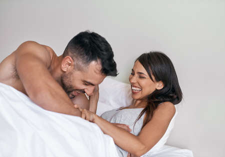 My own personal alarm. an affectionate young married couple in bed at home.