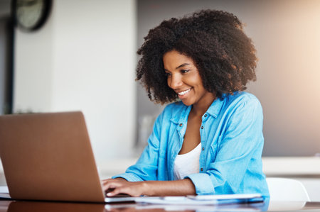 Wake up and work for it, its that easy. an attractive young woman working on her laptop at home.の写真素材