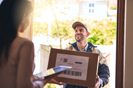 Your order is right here. a courier making a delivery to a customer.の写真素材