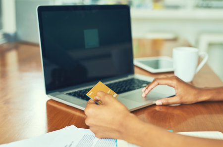 Making some purchases online. an unrecognizable businesswoman doing her banking online at home.