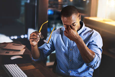 Two seconds away from breaking point. a handsome young businessman experiencing stress during late...