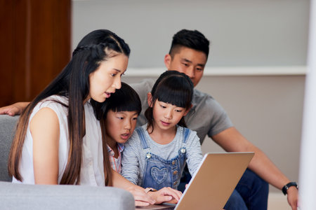 Online is where they find entertainment for everyone. a family using a laptop together at home.