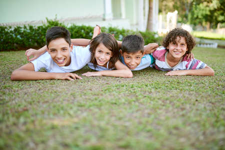 Siblings are one of lifes greatest gifts. Portrait of a group of happy siblings lying together on...