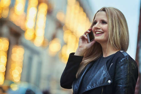 Which one is your apartment. an attractive woman using a mobile phone in the city.
