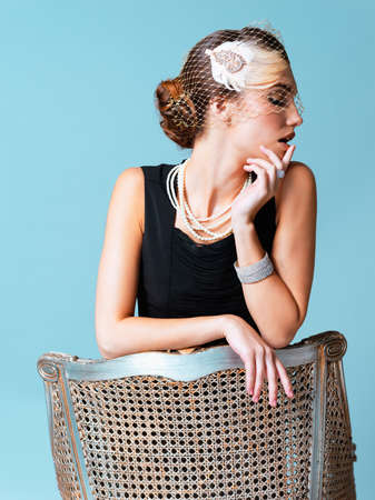 Stay classy and sassy. Studio shot of an elegantly dressed young woman posing against a blue...