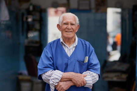 The barber shop where boys become men. Portrait of a senior man in his barber shop.の写真素材