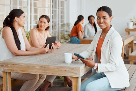 Business woman in office cafeteria or canteen texting, browsing and scrolling on phone during coffee break in creative startup agency. Portrait of smiling, happy and trendy designer on social mediaの写真素材