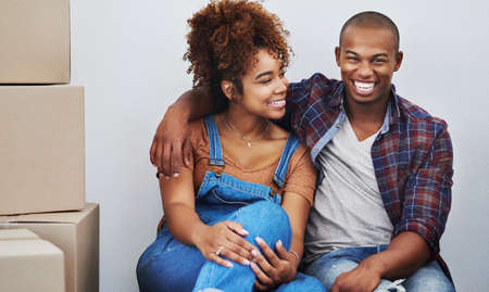 Overjoyed at their new place. an attractive young couple moving house.の写真素材