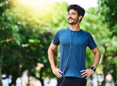 Getting started on a healthier lifestyle. a sporty young man listening to music while exercising...