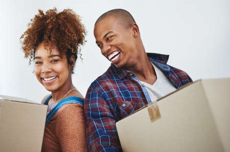 Unpacking one box at a time. an attractive young couple moving house.の写真素材