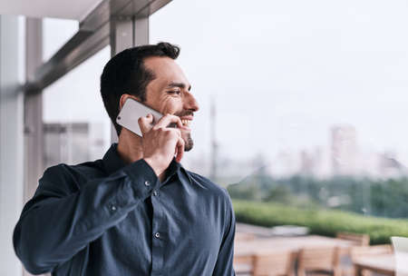 On call busy making success happen. a young businessman talking on a cellphone in an office.