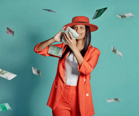Cash, fashion and rich lady throwing money and spending away smiling as she shows off her wealth after shopping. Trendy, happy and winning luxury woman with 100 dollar bills in the air at the casino.の写真素材