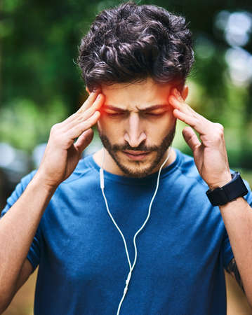 Where did this splitting migraine come from. a sporty young man suffering with a headache while...