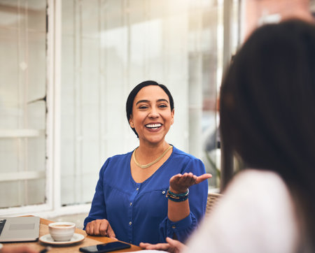 What are your views on the subject. a cheerful young creative businesswoman having a discussion with coworkers at a meeting around a table in a coffeeshop.の写真素材