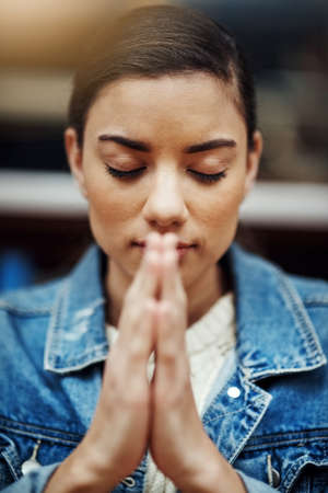 Her strength comes from above. an attractive young woman praying for help with her upcoming university exams.の写真素材