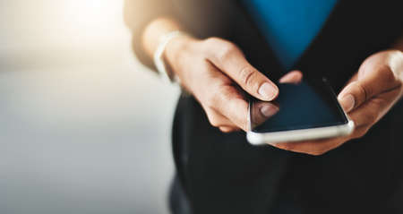 Trendy business women texting on phone, reading text messages and looking at latest trends on social...