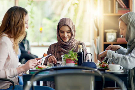 Friends who eat with you are friends for life. a group of women getting together for lunch in a cafe.の写真素材