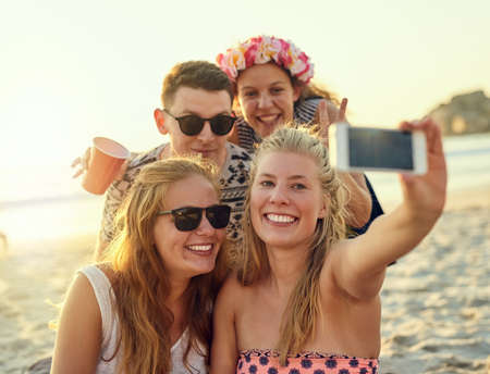 Capturing our moments together. young people hanging out at the beach.