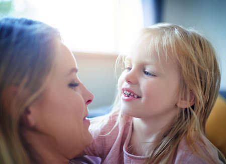 Sweet moments with mom. an adorable little girl bonding with her mother at home.の写真素材