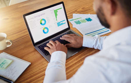 Business man planning with finance graph on laptop at work, working on stats and data and doing...