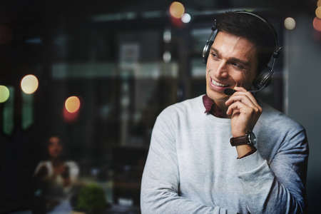 a handsome young businessman looking thoughtful working late in a call center.