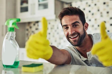 Housework is not just for women. a handsome young man cleaning his home.