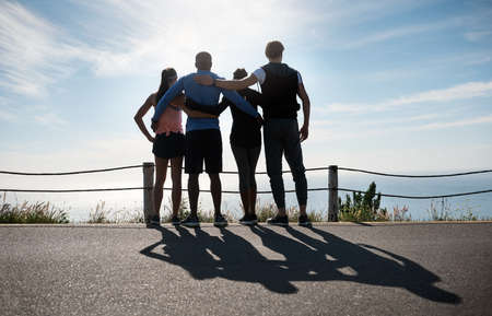 Its all worth it at the end. Rearview shot of a fitness group admiring the view outdoors.の写真素材